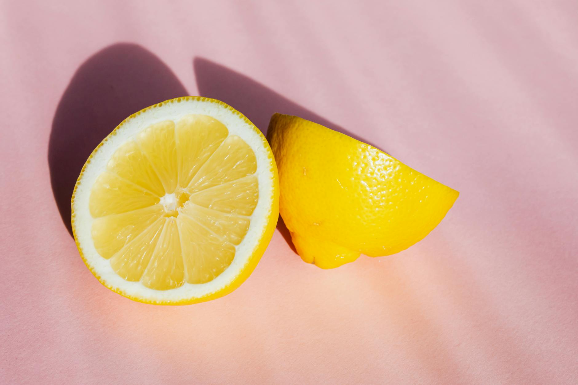 Fresh yellow lemons on a pink background, symbolizing renewal and restoration