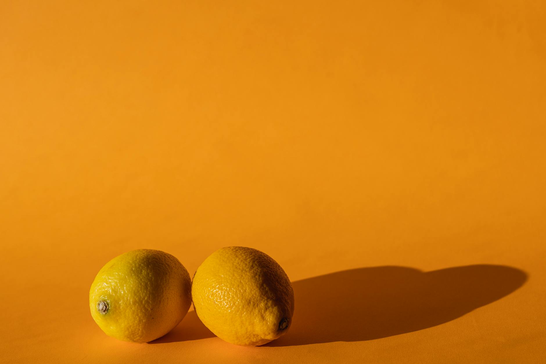 Citronsfrais exposés sur un fond jaune vif, composés en studio avec une lumière éclatante.